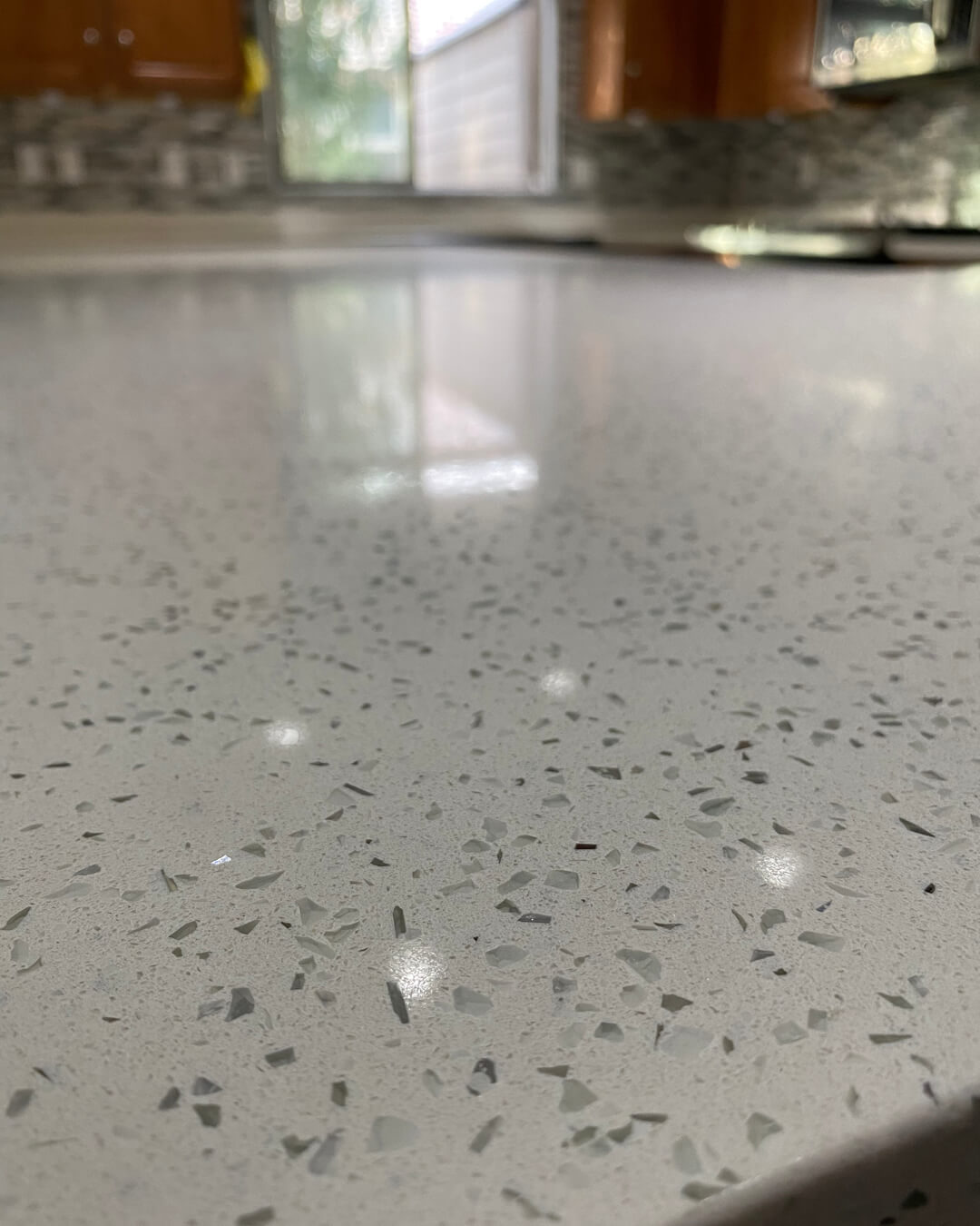 Close-up of a white quartz countertop with small reflective flecks.
