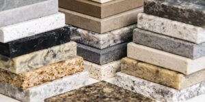 Stacked samples of various countertop materials showing different colors, patterns, and textures.